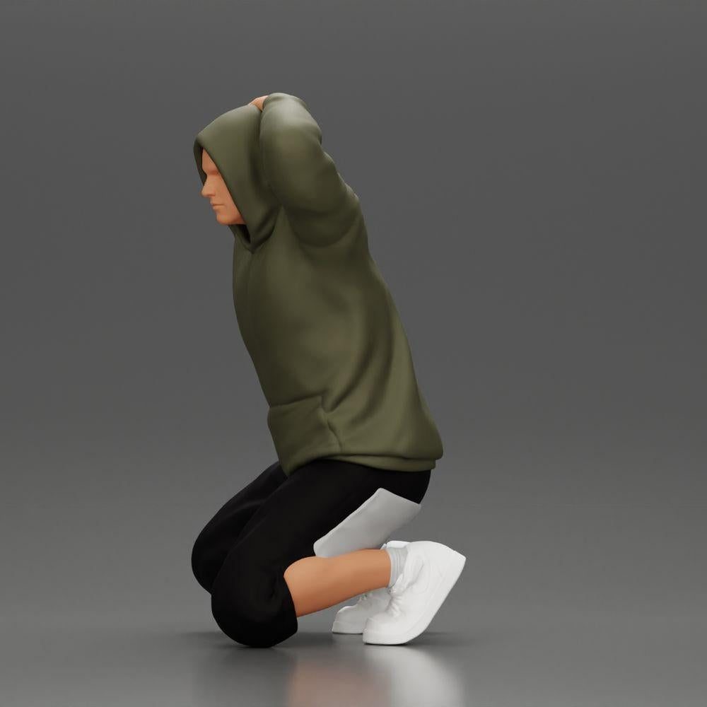 Foto del producto de modelismo diorama 4: Hombre arrodillado con sudadera con capucha, manos detrás de la cabeza - Miniatura de diorama (Ref Nr. A70)