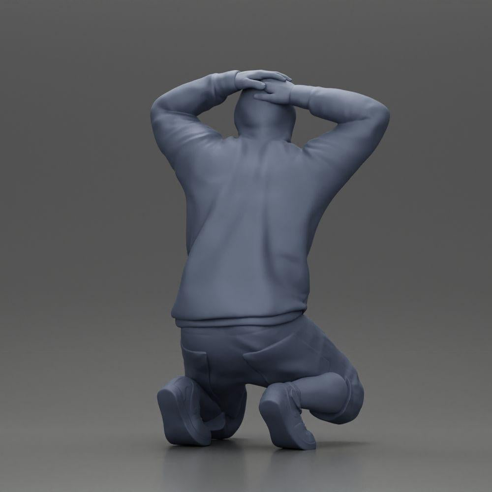Foto del producto de modelismo de diorama 8: Hombre arrodillado con sudadera con capucha, manos detrás de la cabeza - Miniatura de diorama (Ref Nr. A70)